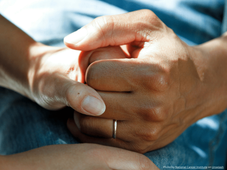 Two people holding hands, symbolizing support and connection in social and relationship self-care